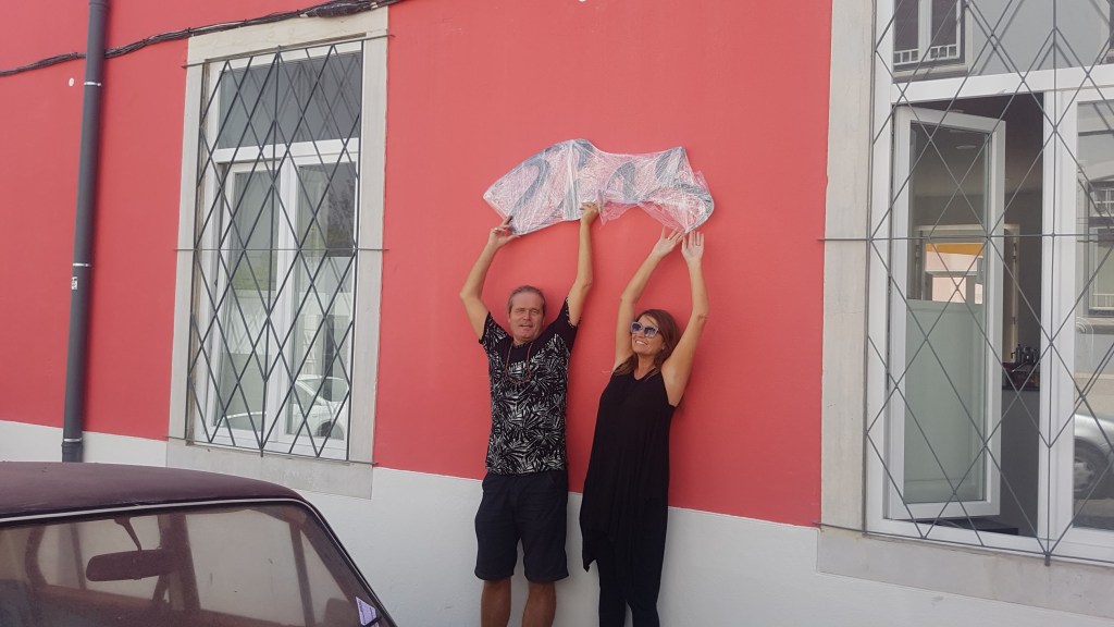 Thomas and Annette hanging the Tings Lisbon iron sign on their renovated house in Graça, Lisbon.