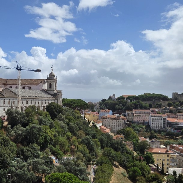 Construction crane over historic convent buildings looking toward Castelo de São Jorge in Lisbon.